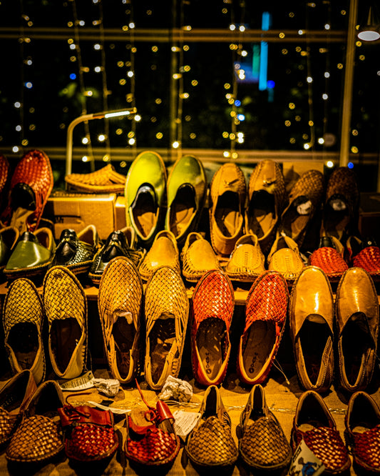 a pile of shoes sitting on top of a wooden floor