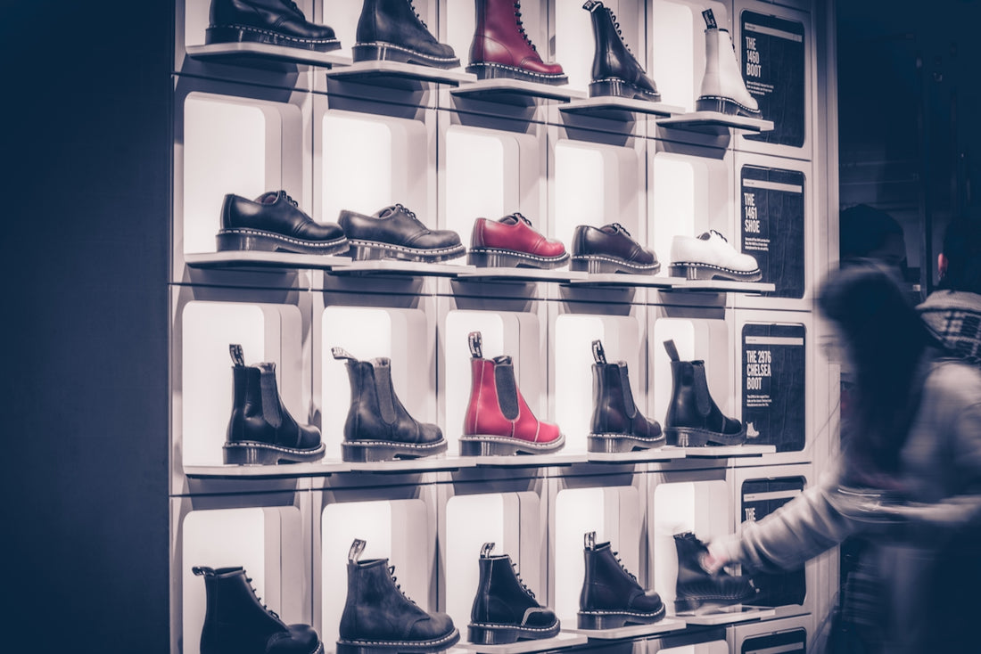 a woman standing in front of a display of shoes
