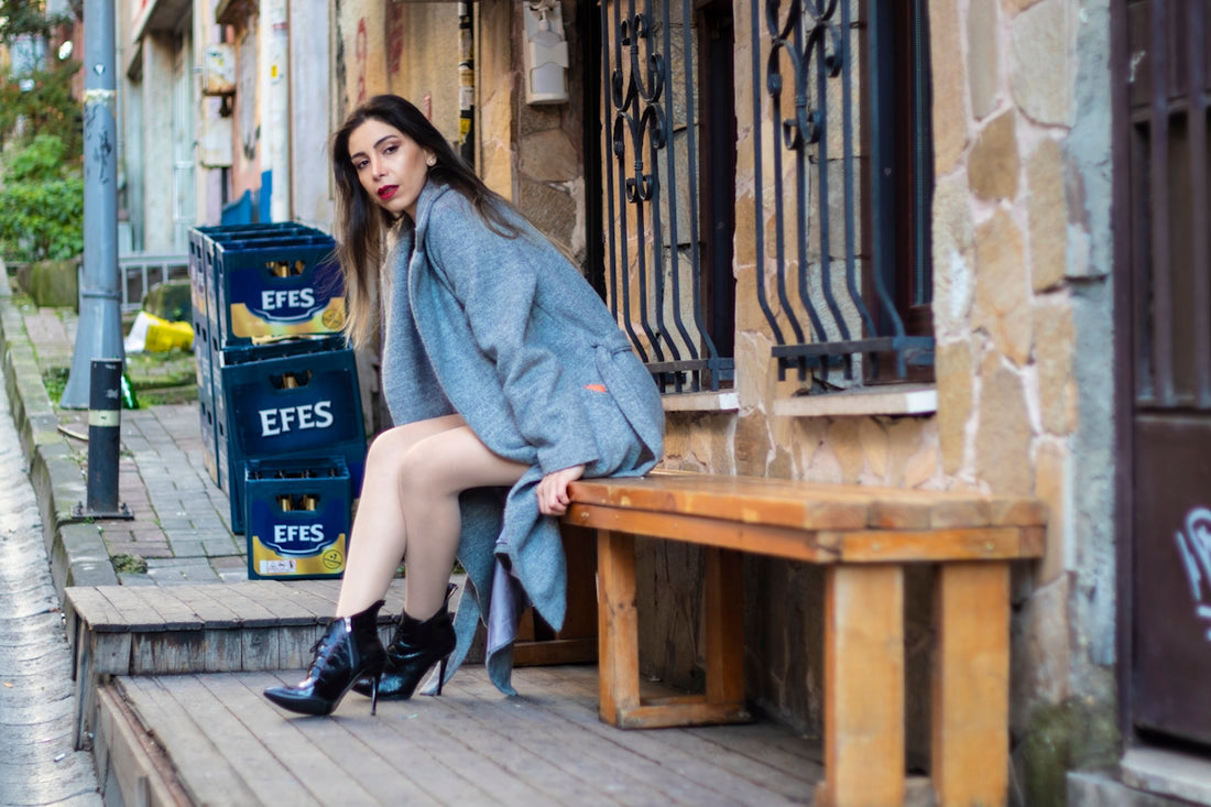 A woman sitting on a bench in front of a building