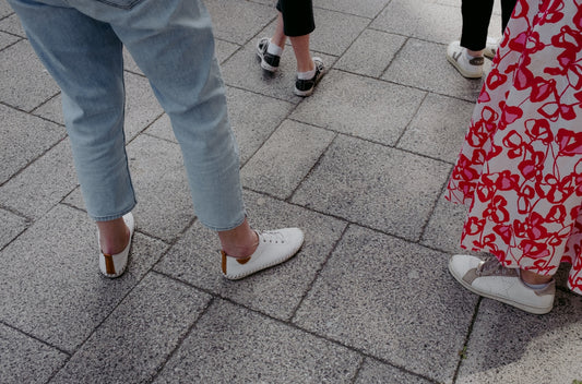 A group of people standing on top of a sidewalk