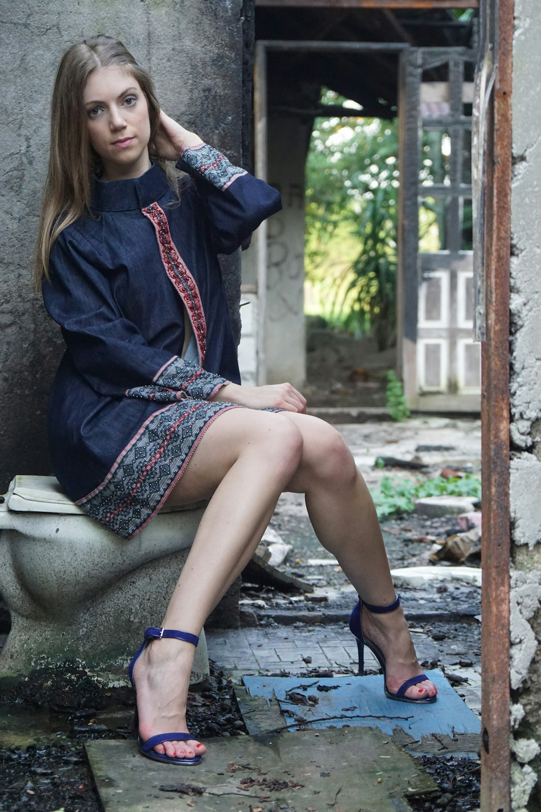 A woman is sitting on a toilet outside