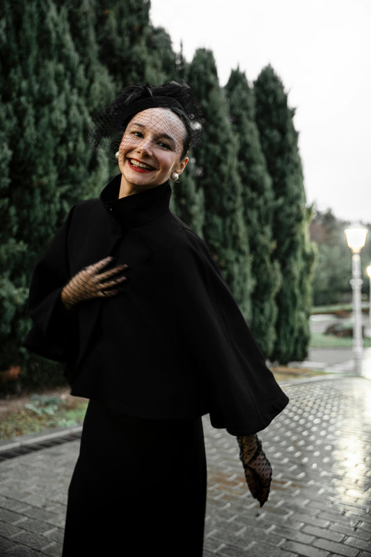 A woman in a black dress is smiling