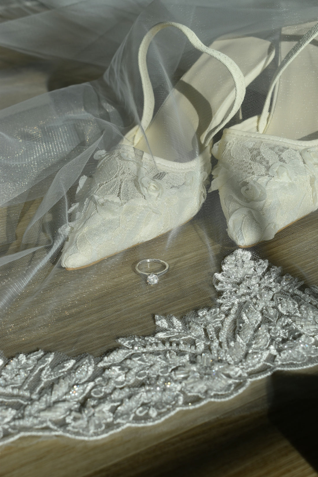 Wedding ring and shoes on a bridal veil.