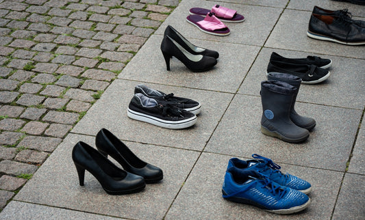 Assortment of shoes arranged on pavement